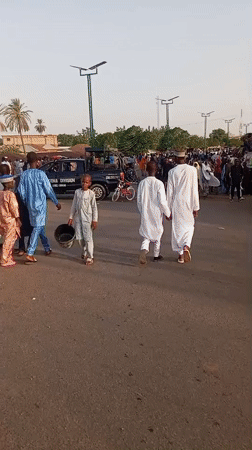 Traditional-dressed crowd walks through Arawa, Nigeria streets