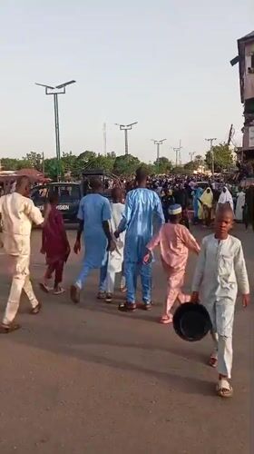 Traditional-dressed crowd walks through Arawa, Nigeria streets