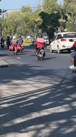 Busy morning traffic and roadside activity on Gelam's main street