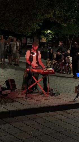 Street keyboardist performing under red lights in Montreal