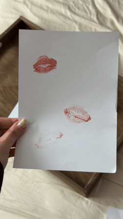 Person creates lipstick kiss art collection in Krasnodar bedroom
