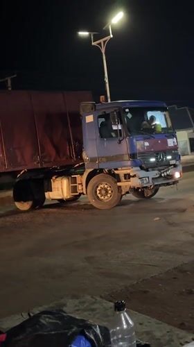 Commercial trucks stop in Bukuru as street vendors operate