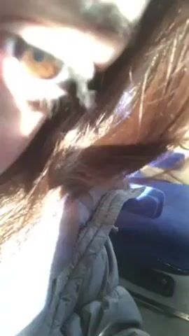 The video shows a close-up of a person's eye and eyebrow. The eye is brown with a dark pupil. The eyebrow is brown and somewhat bushy. The person's hand is visible near the eye. Part of a jacket is in the lower portion of the view. The light is bright and natural.