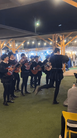 Historical string ensemble performs at a lively nighttime outdoor event in Arica