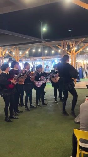 Historical string ensemble performs at a lively nighttime outdoor event in Arica