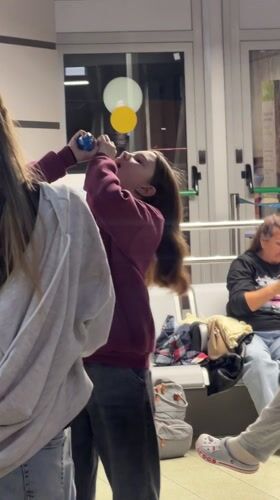 Woman finishes drink from plastic container in Adler