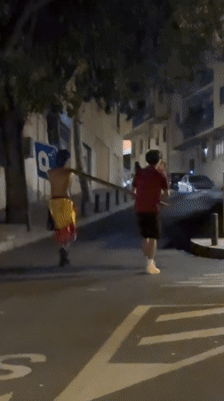Carrying a wooden pole through El Escorial streets at night