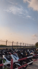Motorbike parking lot documented near fenced area in Thailand
