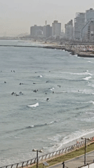 Early morning surfers gather in Tel Aviv waters