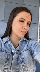 Woman records selfies against tiled wall in Chaikovsky