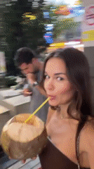 Woman enjoys coconut drink at Kuala Lumpur rooftop pool