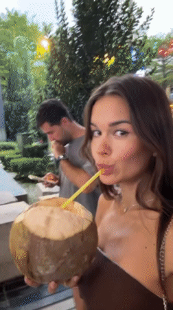Woman enjoys coconut drink at Kuala Lumpur rooftop pool