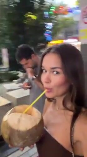Woman enjoys coconut drink at Kuala Lumpur rooftop pool