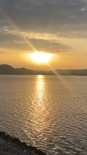 Golden sunrise reflected over still waters near Dam Camp