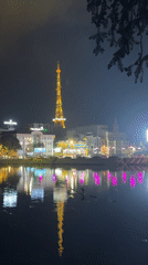 Da Lat's illuminated Vinaphone tower reflects in lake waters