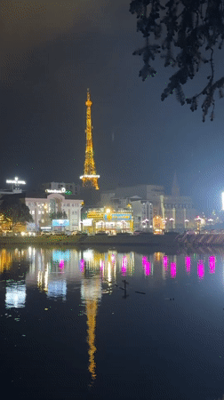 Da Lat's illuminated Vinaphone tower reflects in lake waters