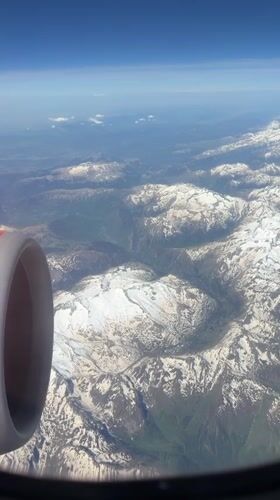 Passenger films mountainous landscape from airplane window over UK