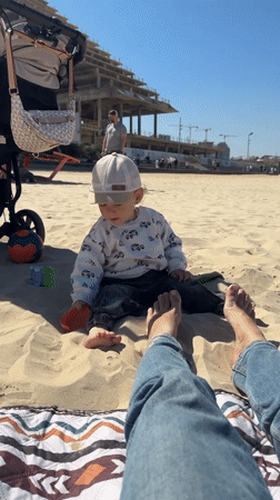 Toddler enjoys sunny morning on Bat Yam beach