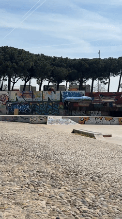 Skateboarders gather at graffiti-covered Barcelona park on sunny morning