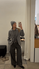Woman in gray outfit shops with phone in Oelde store