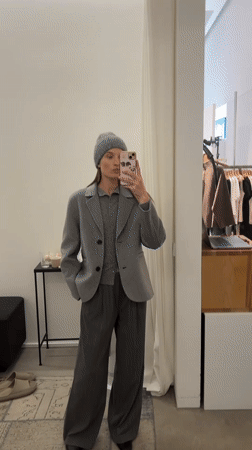 Woman in gray outfit shops with phone in Oelde store