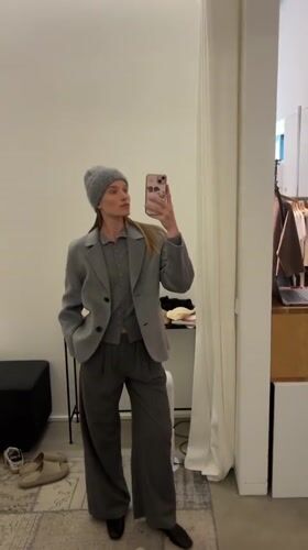 Woman in gray outfit shops with phone in Oelde store