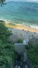 Woman sunbathes on mossy rocks at Ungasan beach resort