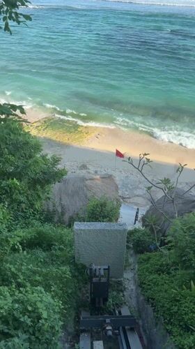 Woman sunbathes on mossy rocks at Ungasan beach resort