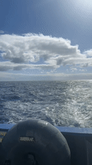 Boat crosses choppy Atlantic waters under sunny skies