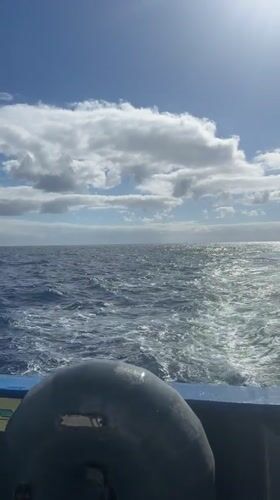 Boat crosses choppy Atlantic waters under sunny skies