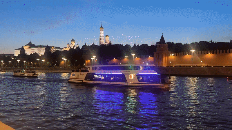 Passenger boat passes the Kremlin on the Moscow River at dusk