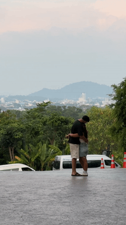 Couple embraces at scenic overlook during Wichit evening market
