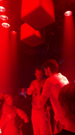 Rose presentation at a red-lit Moscow gathering