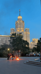 Fire performers juggle flames near Moscow landmark at dusk