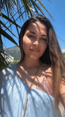 Woman poses by palm tree in coastal Montenegro