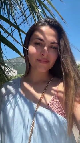 Woman poses by palm tree in coastal Montenegro