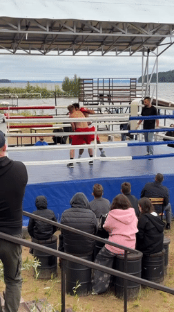 Outdoor boxing match draws a crowd near the water