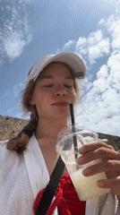 Woman enjoys drink while walking in Budva, Montenegro