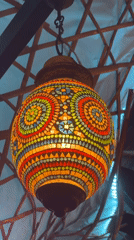 Mosaic-covered spherical lantern observed hanging indoors