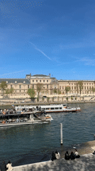 Seine River boat traffic observed near Louvre on sunny afternoon
