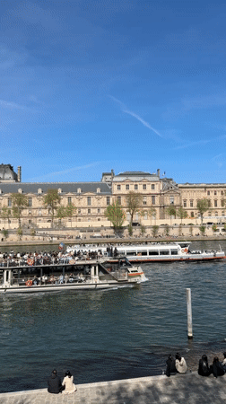 Seine River boat traffic observed near Louvre on sunny afternoon