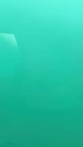 The video is an underwater shot of turquoise water with light reflecting off the surface. The camera is moving horizontally, capturing the movement of the water.