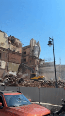 Building demolition underway in Moscow with excavator clearing debris