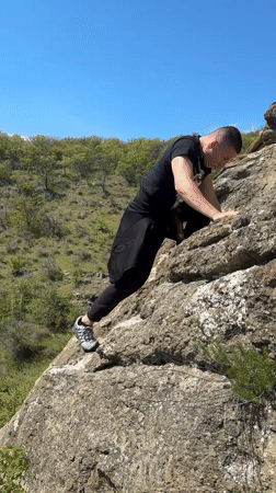 Man poses on rocky cliffs near Goritsa, Bulgaria