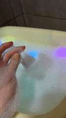 Child enjoys colorful light-up bath toy in Chaikovsky