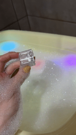 Child enjoys colorful light-up bath toy in Chaikovsky