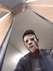 Person in white sheet mask documented during Indonesian rainstorm
