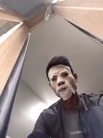 Person in white sheet mask documented during Indonesian rainstorm