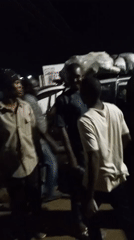 Men load heavy bags onto SUV near agricultural services