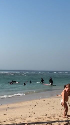 Busy Kuta Selatan beach morning: surf, sand, and monkeys nearby